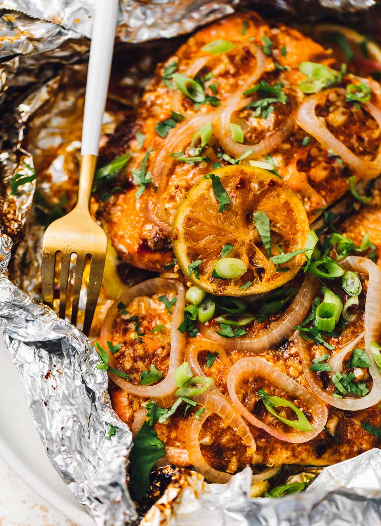 spicy grilled salmon cooked in foil, with fork.