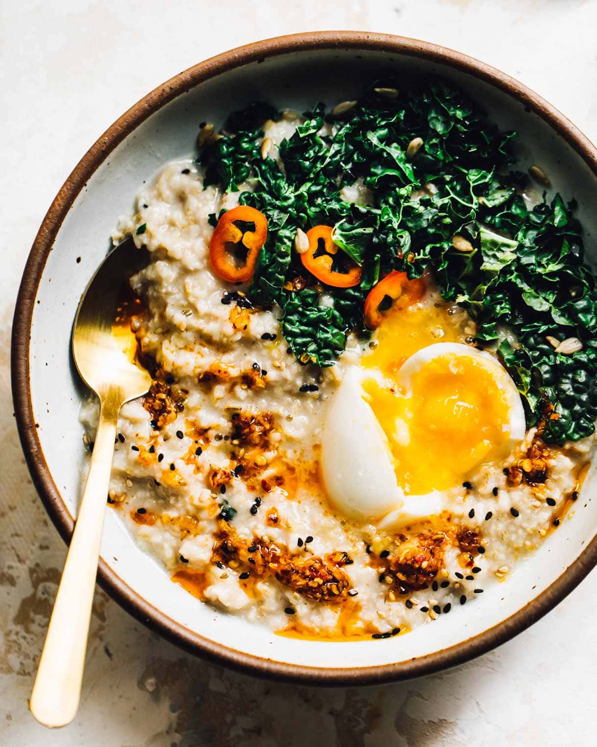 savory oatmeal with an egg, greens, chili oil