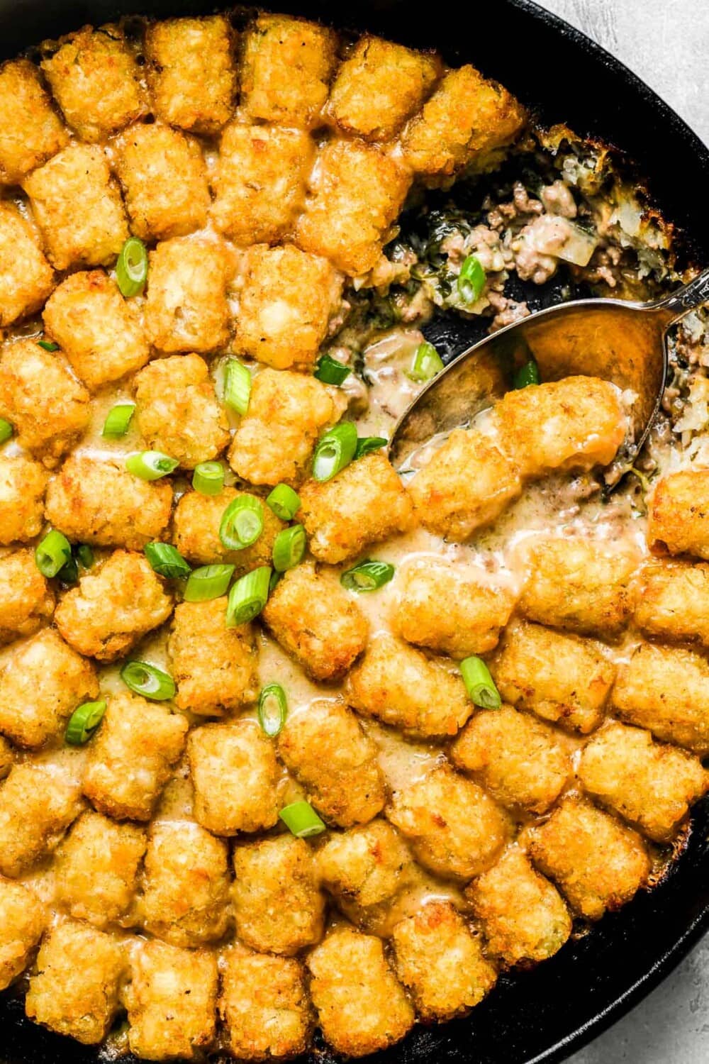 tater tot hotdish with a spoon in it.