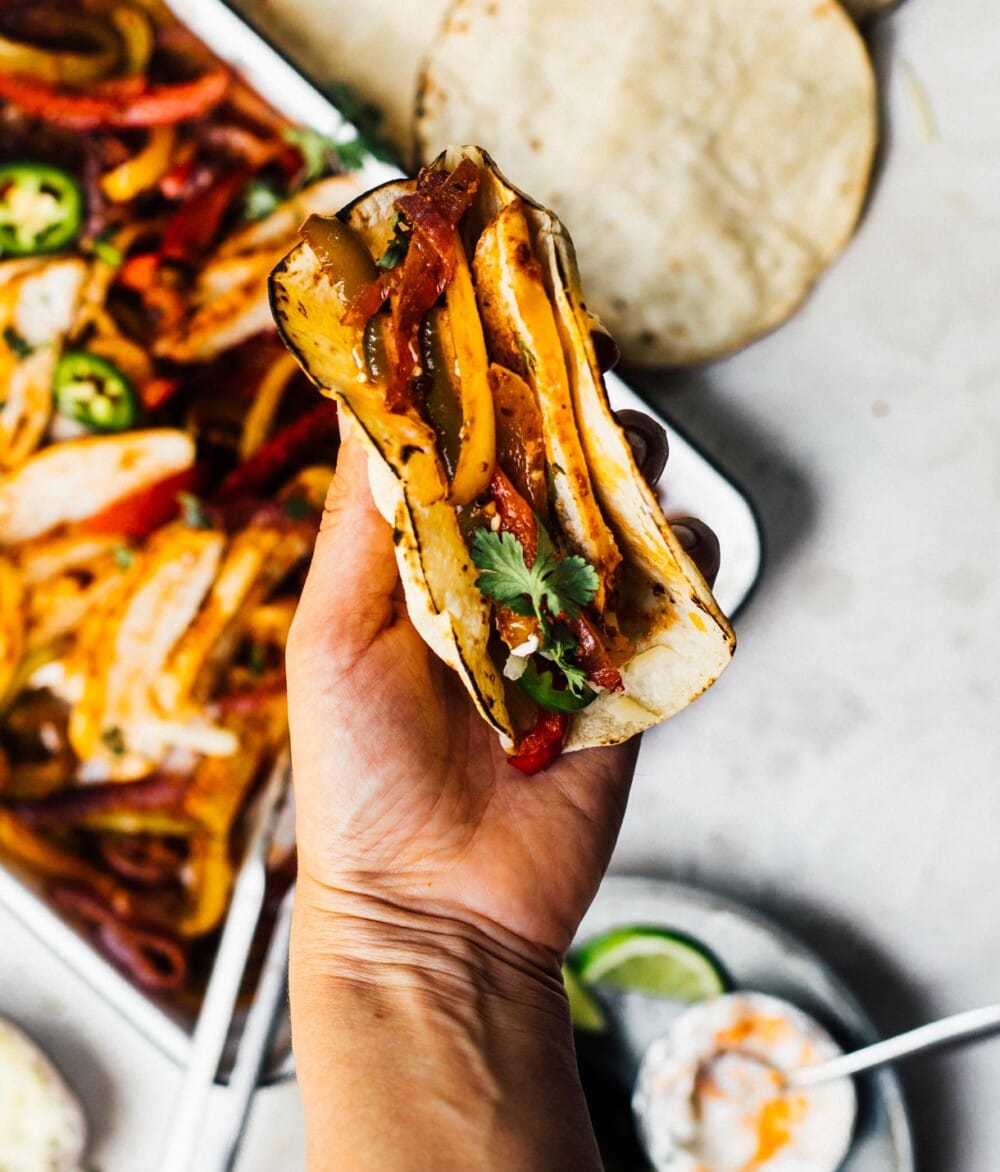 woman holding a fajita in her hand