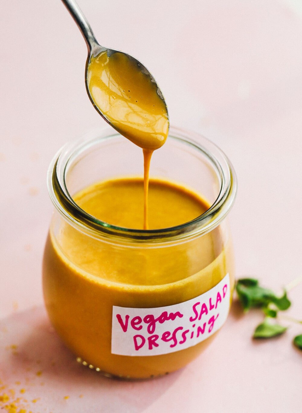 vegan salad dressing being spooned into a glass jar
