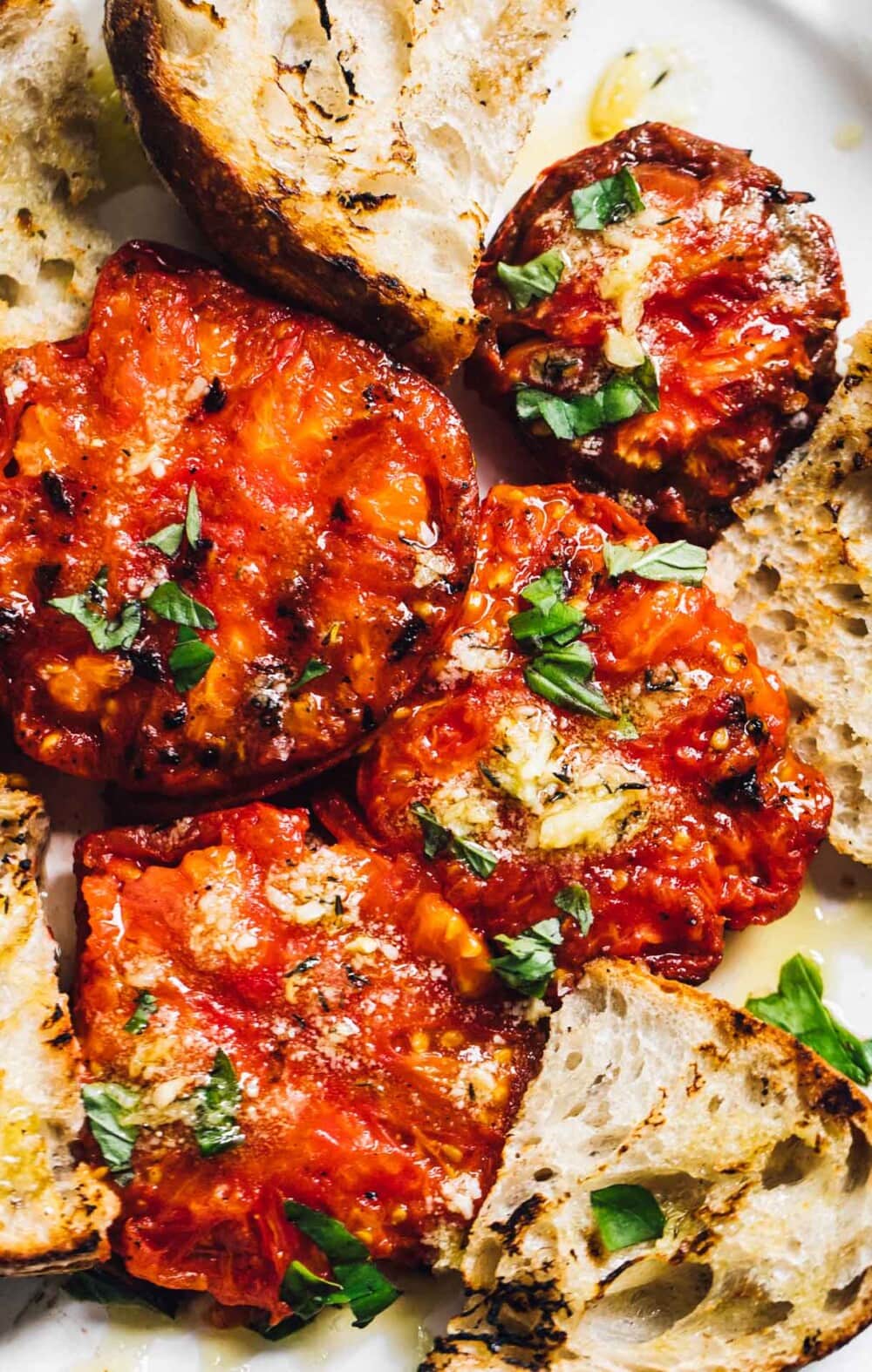 grilled tomatoes with garlic oil, and bread on a plate