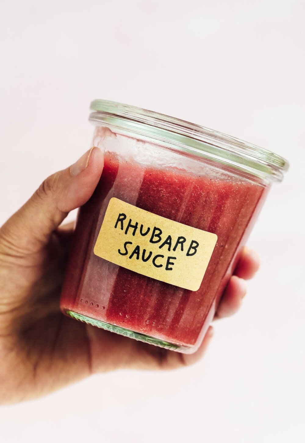 hand holding rhubarb sauce in a weck jar