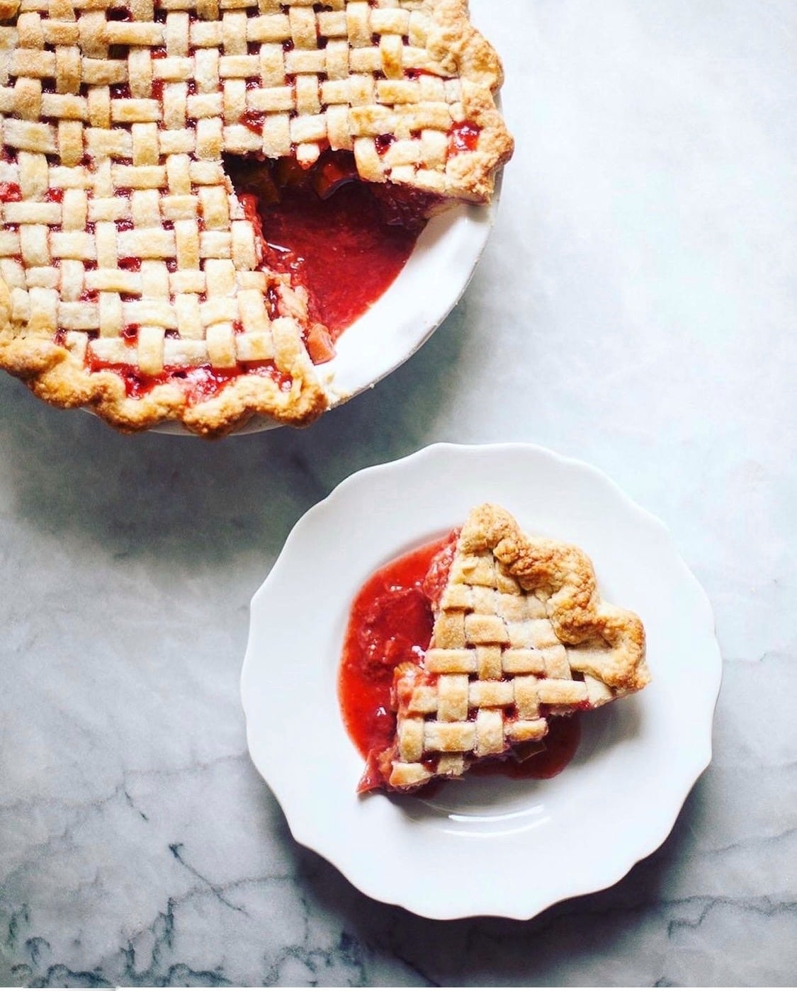 strawberry rhubarb pie with a lattice top, one piece plated.