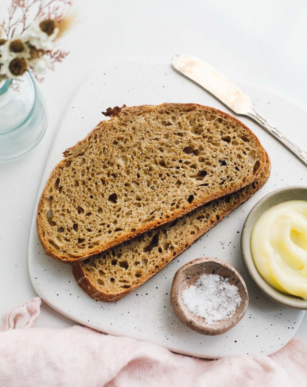 einkorn sourdough bread, sliced on a platter with salt and butter