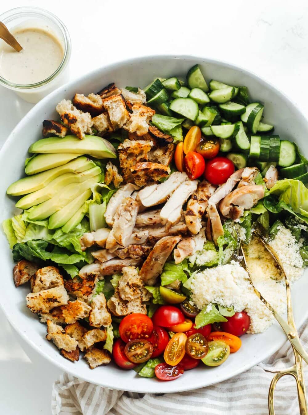 grilled chicken caesar salad ingredients in a large blue bowl