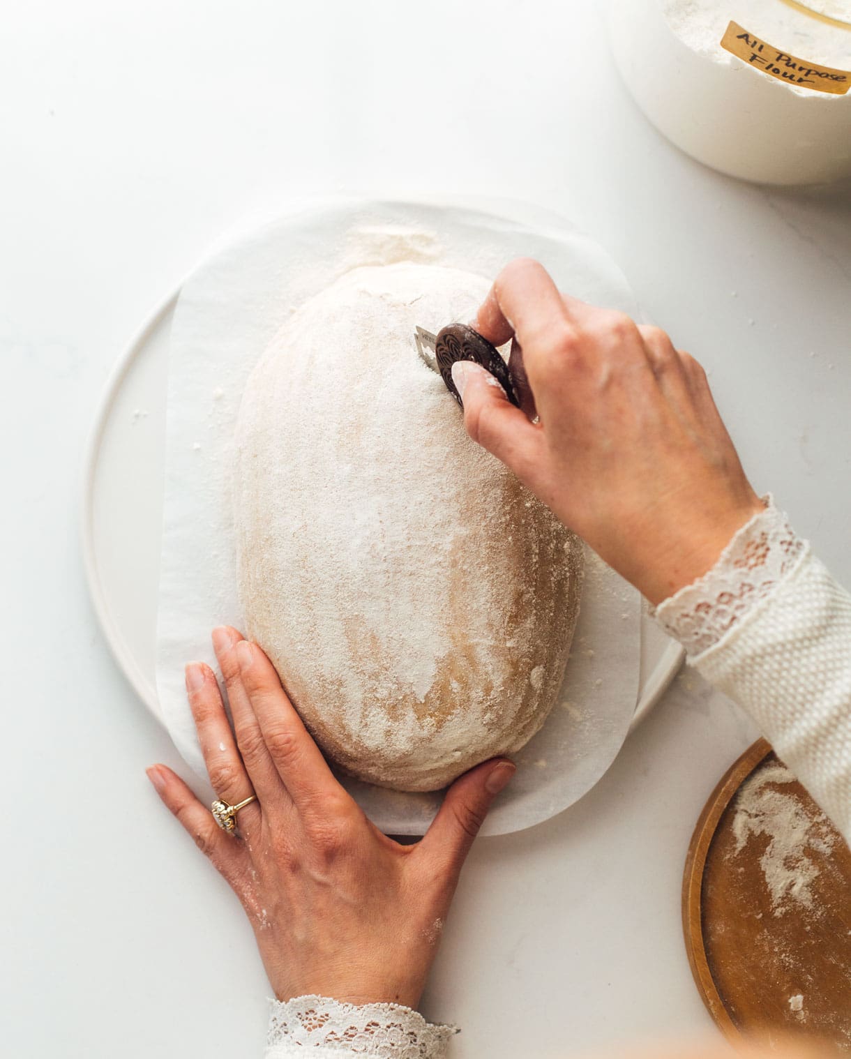 woman scoring sourdough bread