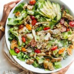 woman holding grilled chicken caesar salad in a bowl