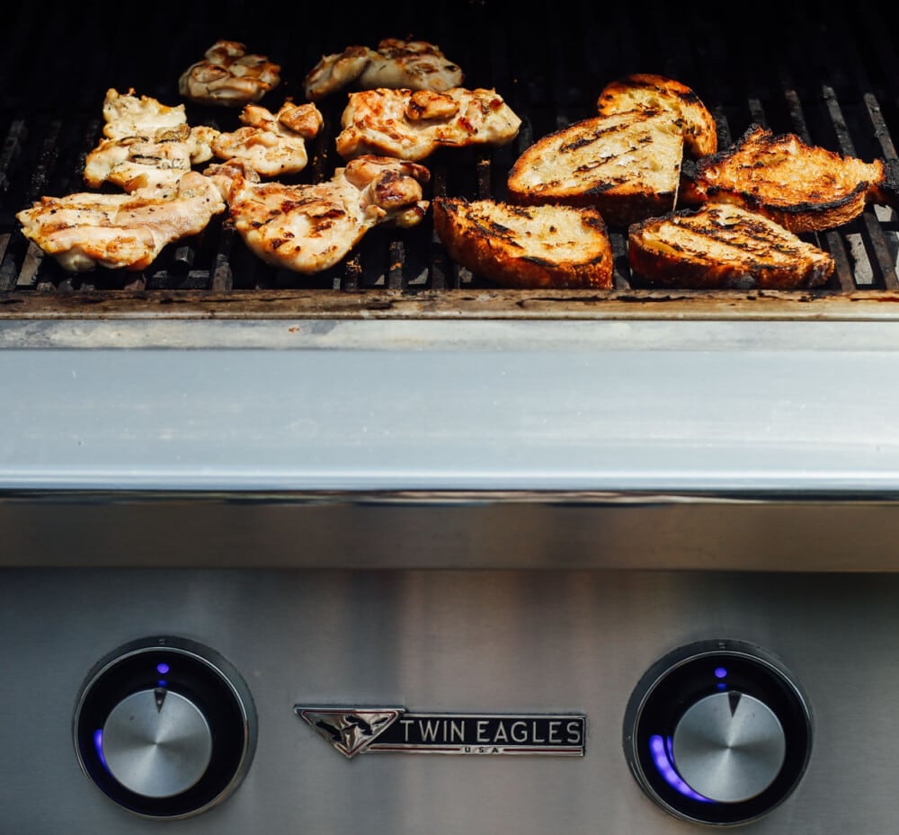 chicken thighs and bread on a grill