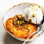 baked peaches with ice cream and crushed pistachios