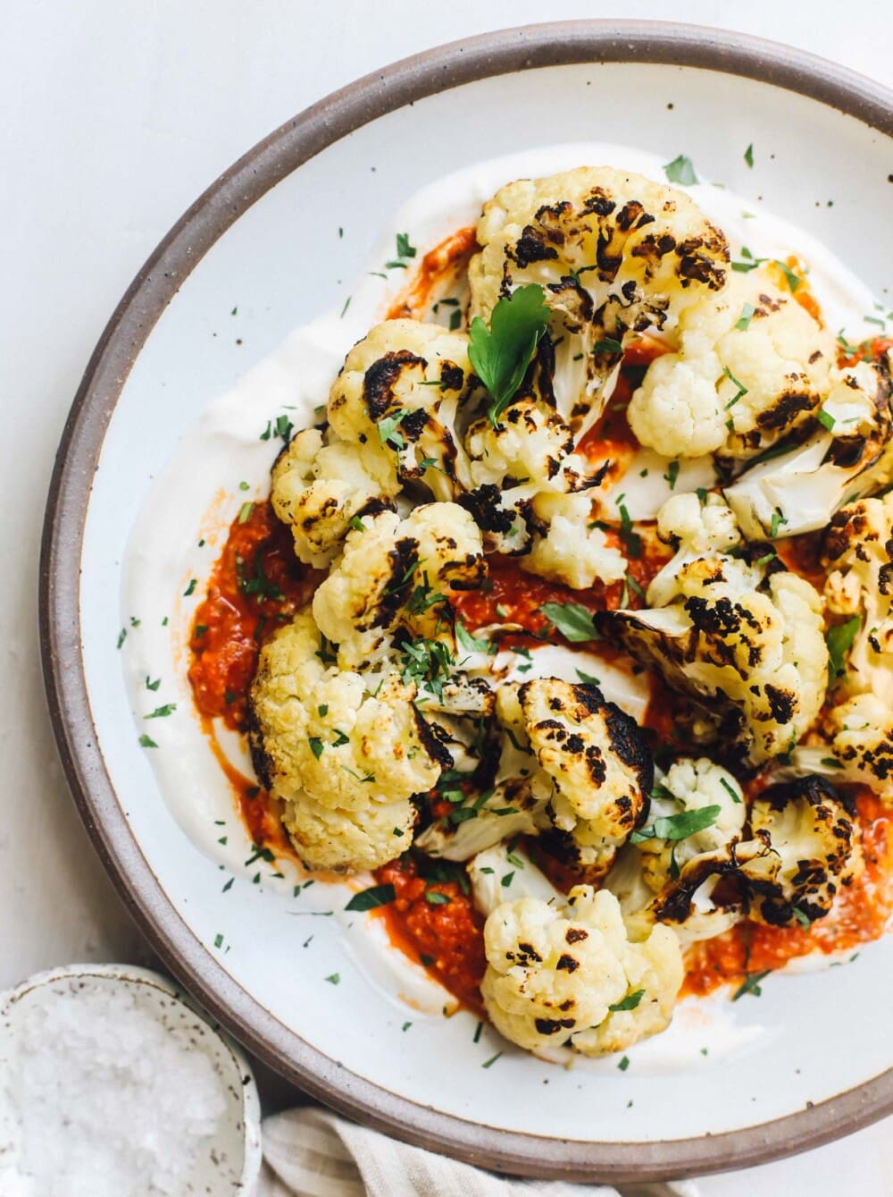 grilled cauliflower with roasted red pepper sauce on white plate