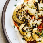 grilled cauliflower florets on a bed of sour cream and romesco sauce