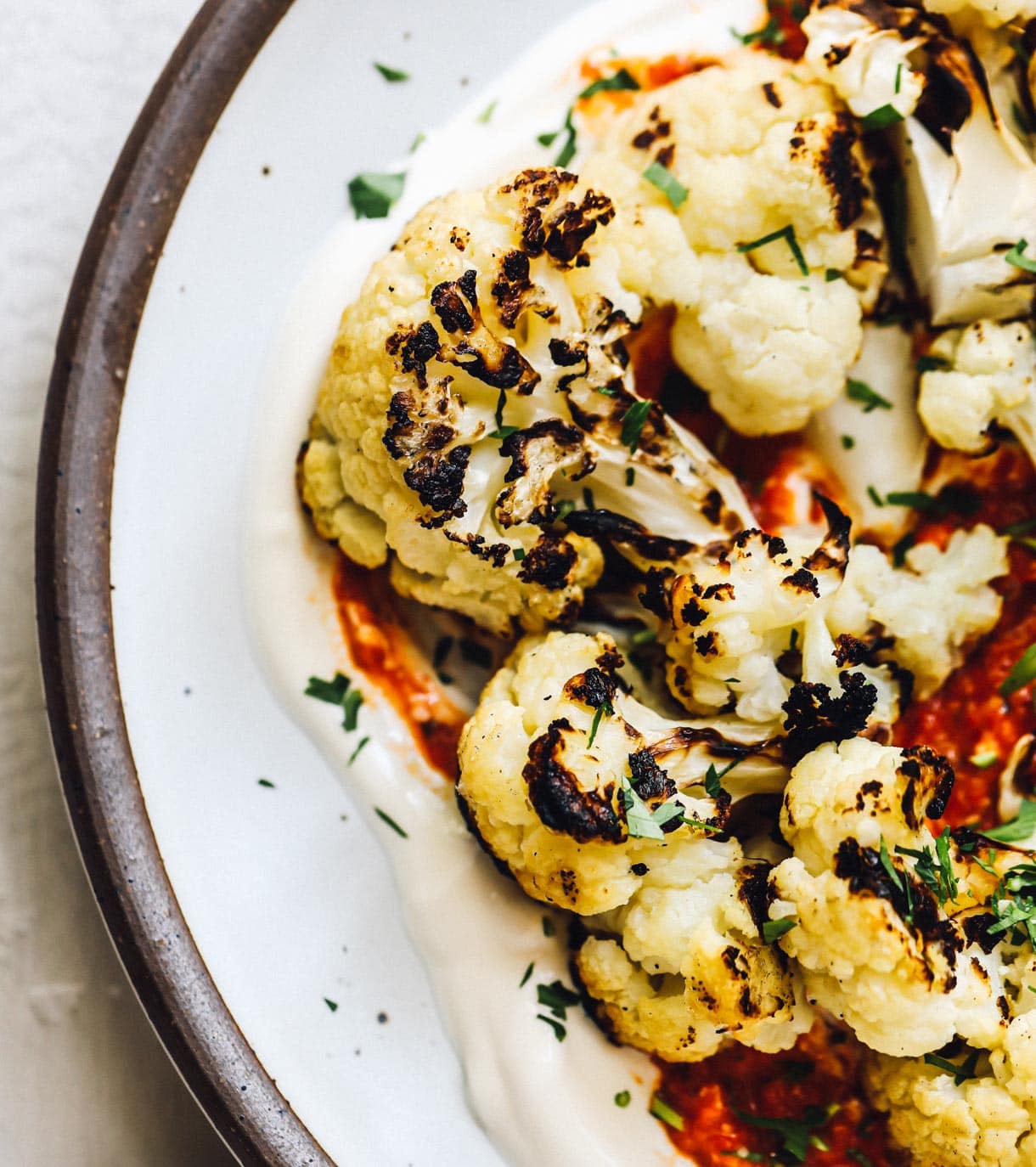 grilled cauliflower florets on a bed of sour cream and romesco sauce