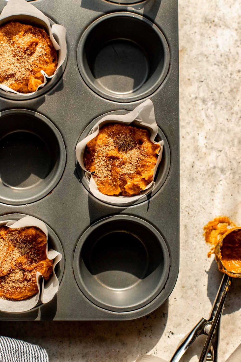 pumpkin muffin batter in a muffin tin, unbaked