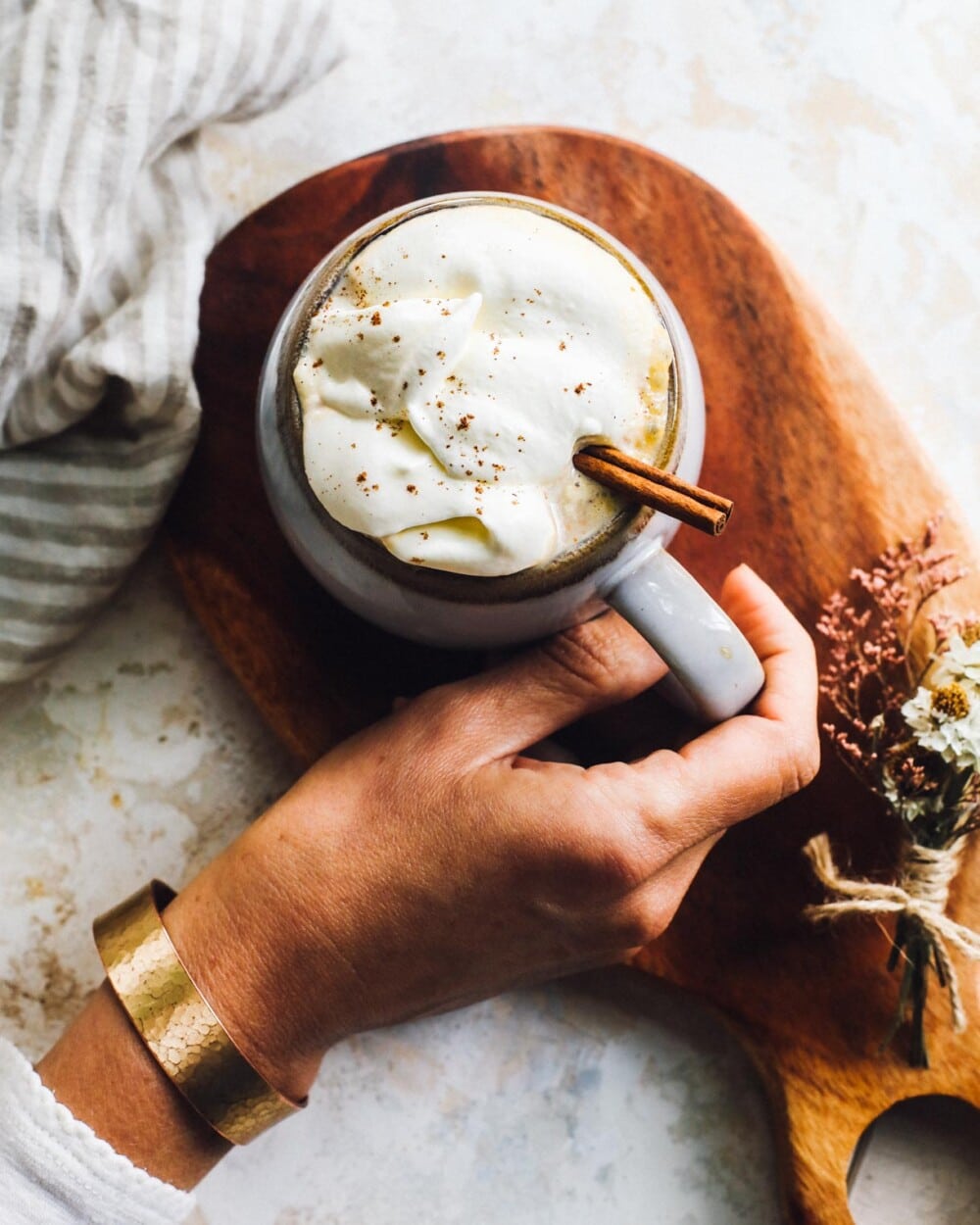 homemade pumpkin latte in hand, with whipped cream