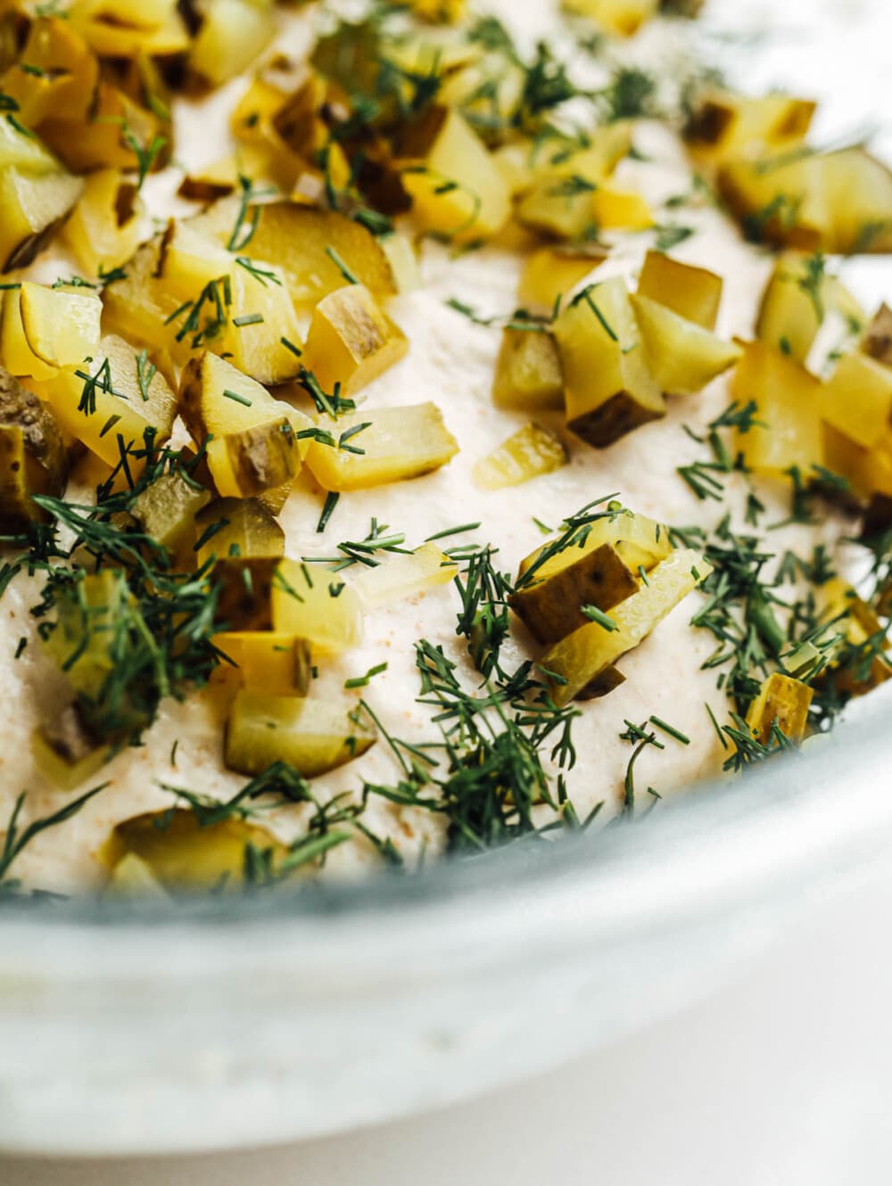 chopped pickles and dill scattered over the top of dough