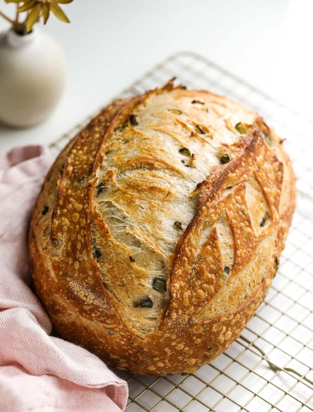 dill pickle sourdough on cooling rack with pink towel