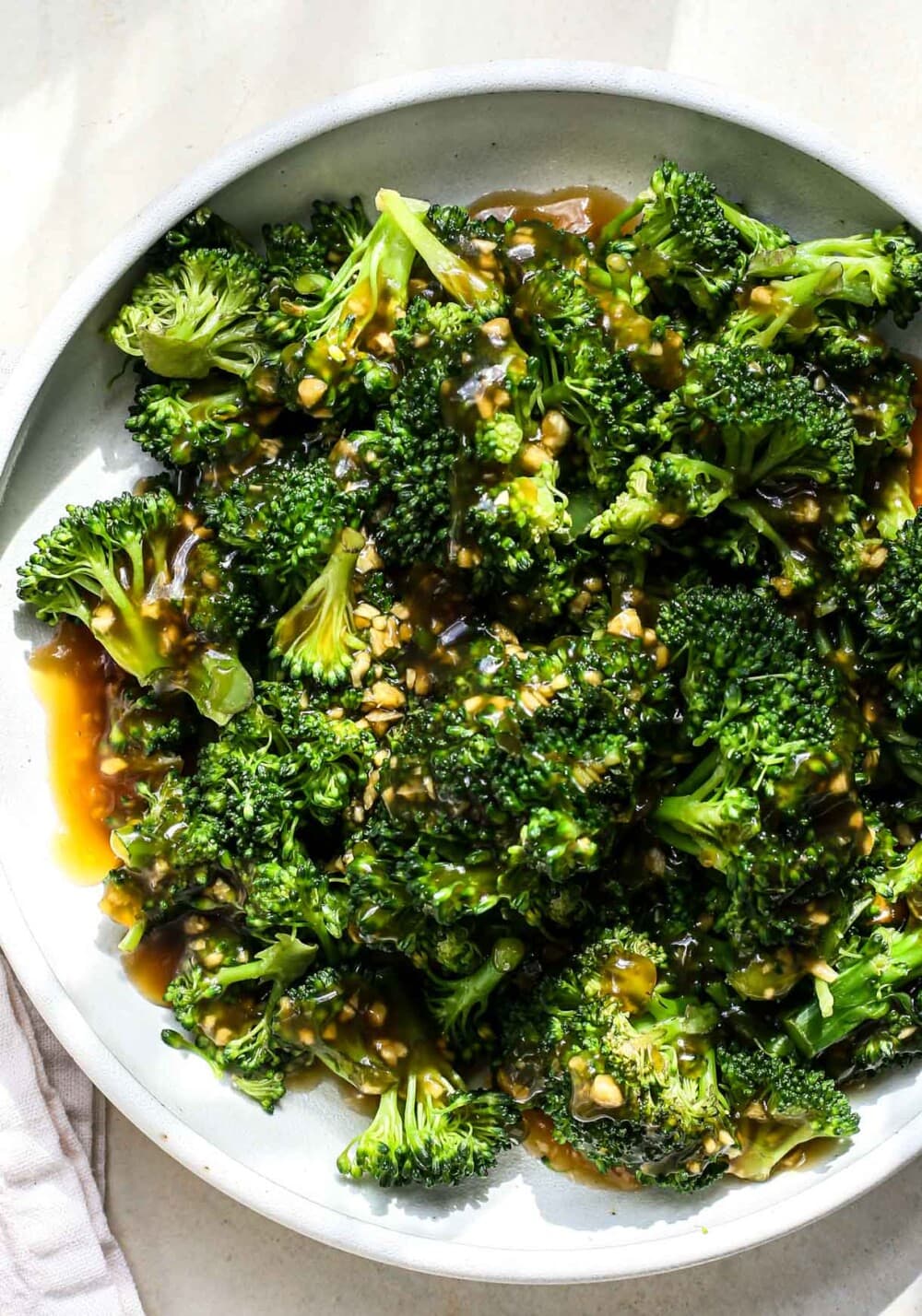 broccoli tossed with gluten-free teriyaki sauce on white plate