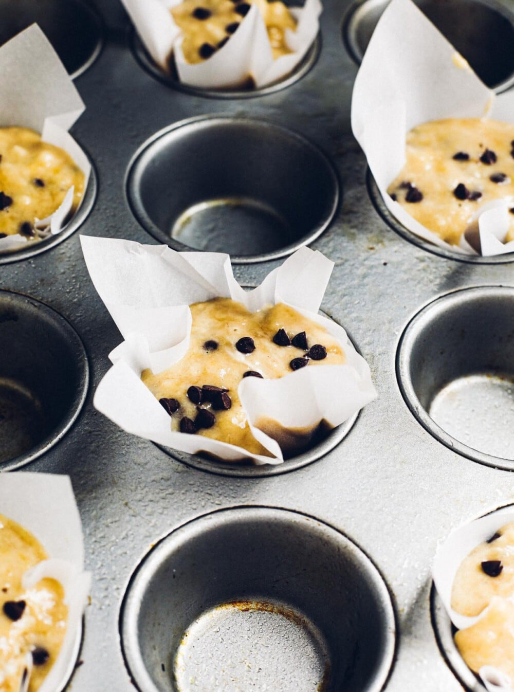 banana chocolate chip muffins in muffin tin, unbaked.