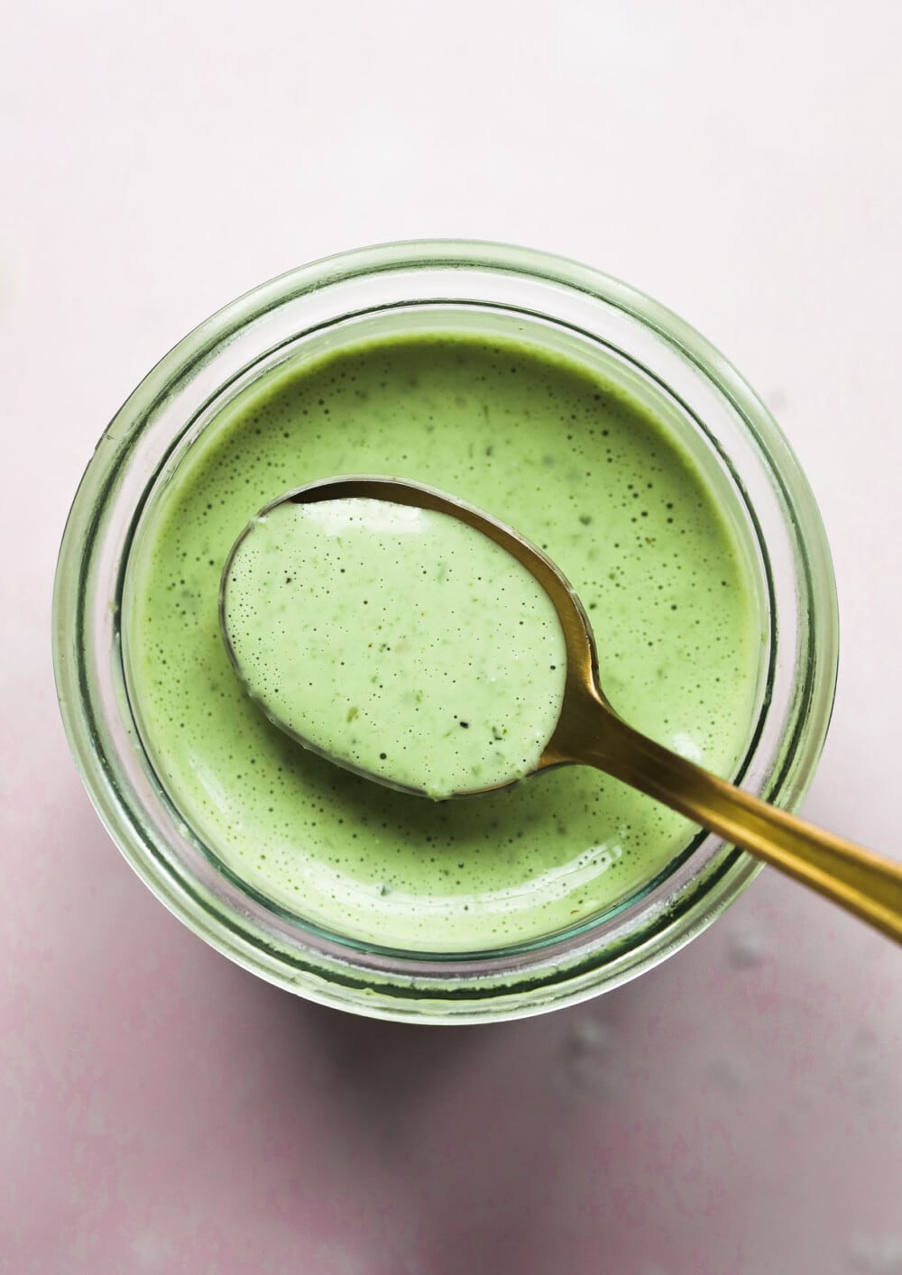 green goddess dressing in clear jar with gold spoon