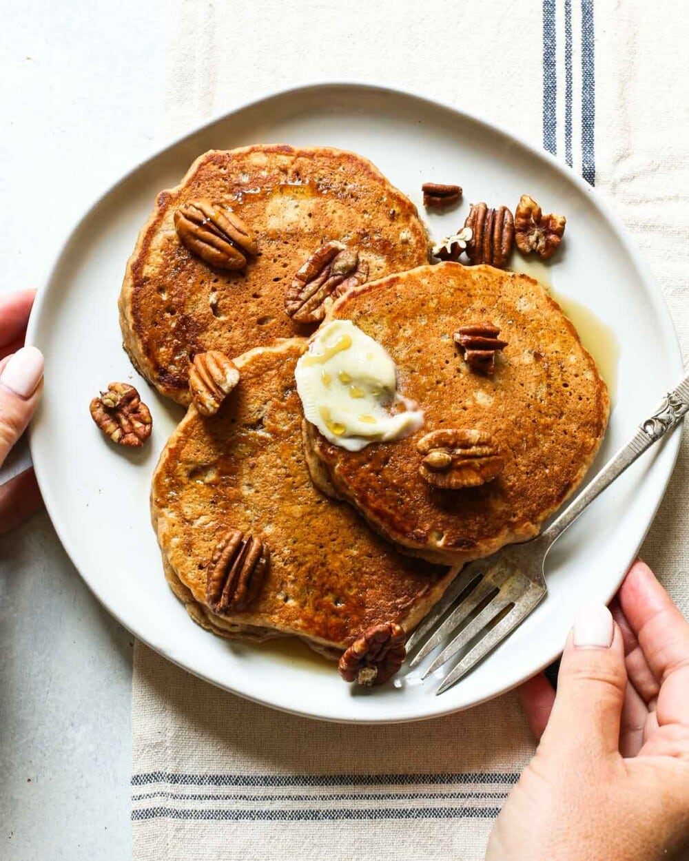 holding a plate of apple butter pancakes