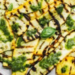grilled summer squash on a plate with basil vinaigrette