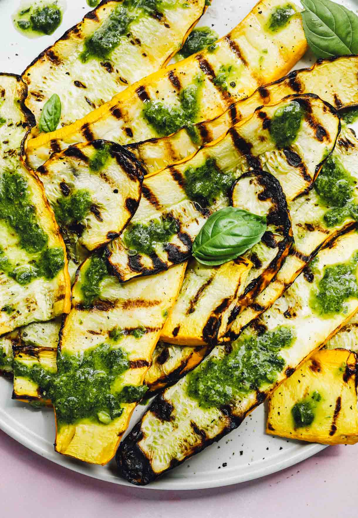 grilled summer squash on a plate with basil vinaigrette