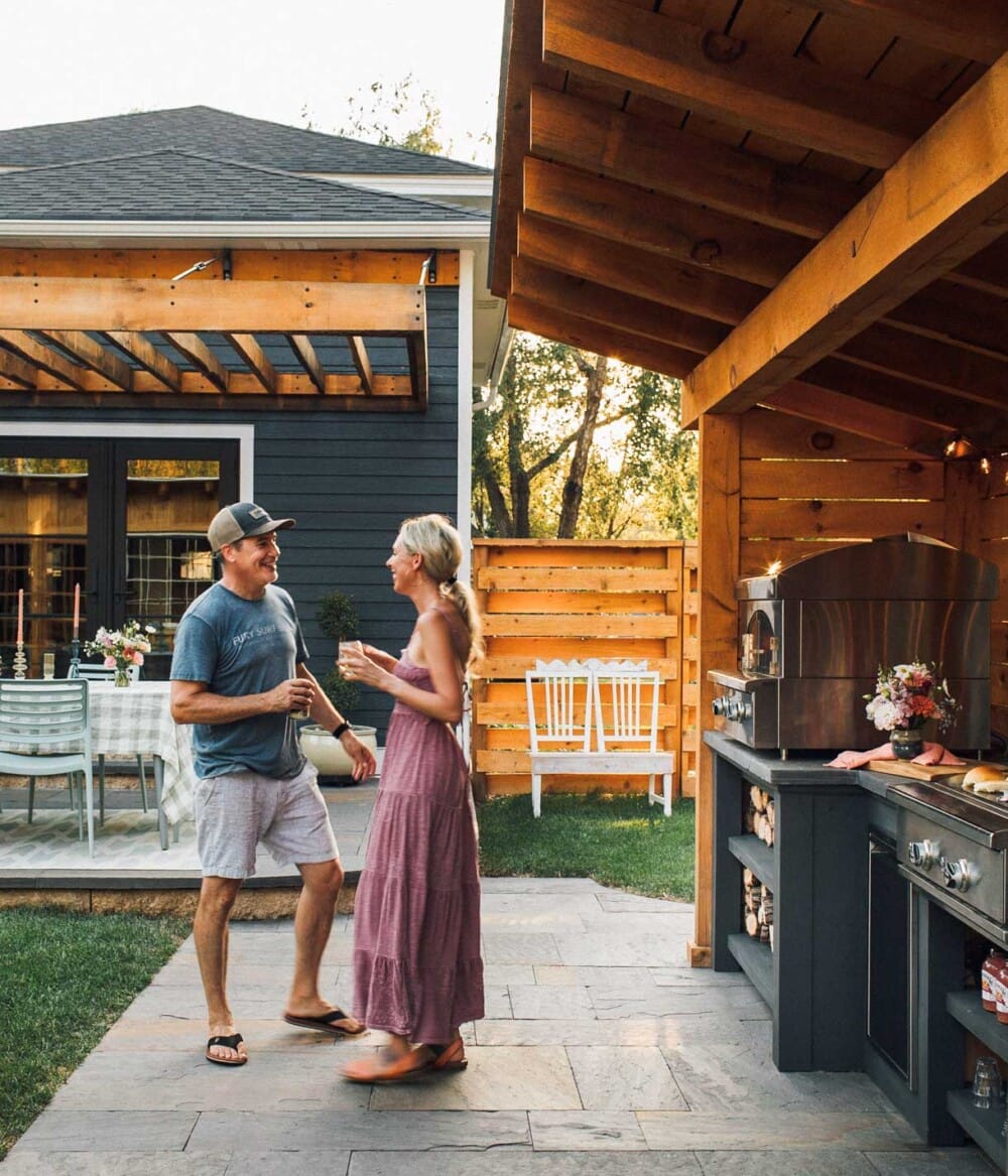 couple dancing outside in a backyard with outdoor kitchen