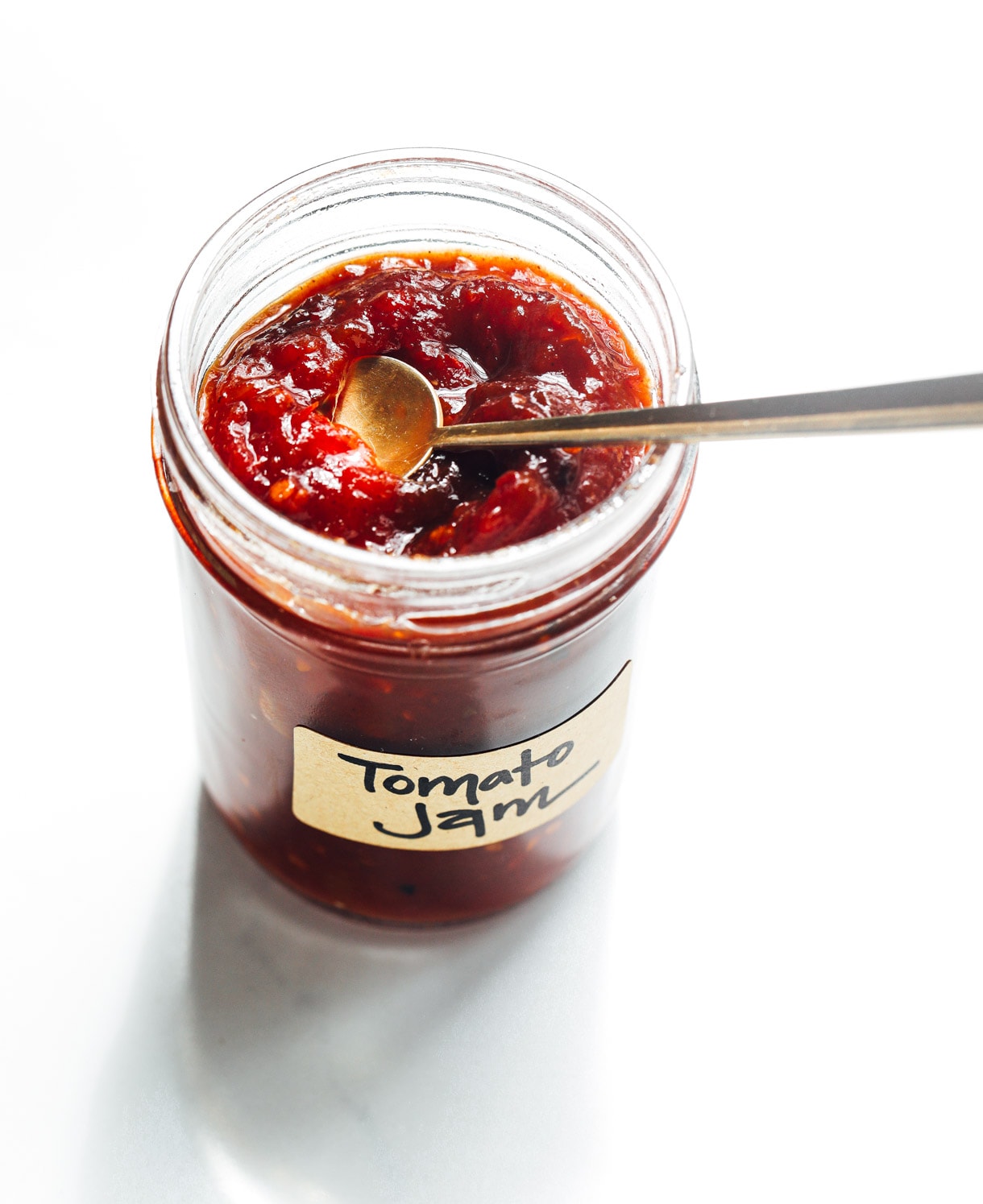 tomato jam in a jar with gold spoon