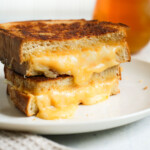 melty sourdough grilled cheese stacked on white plate
