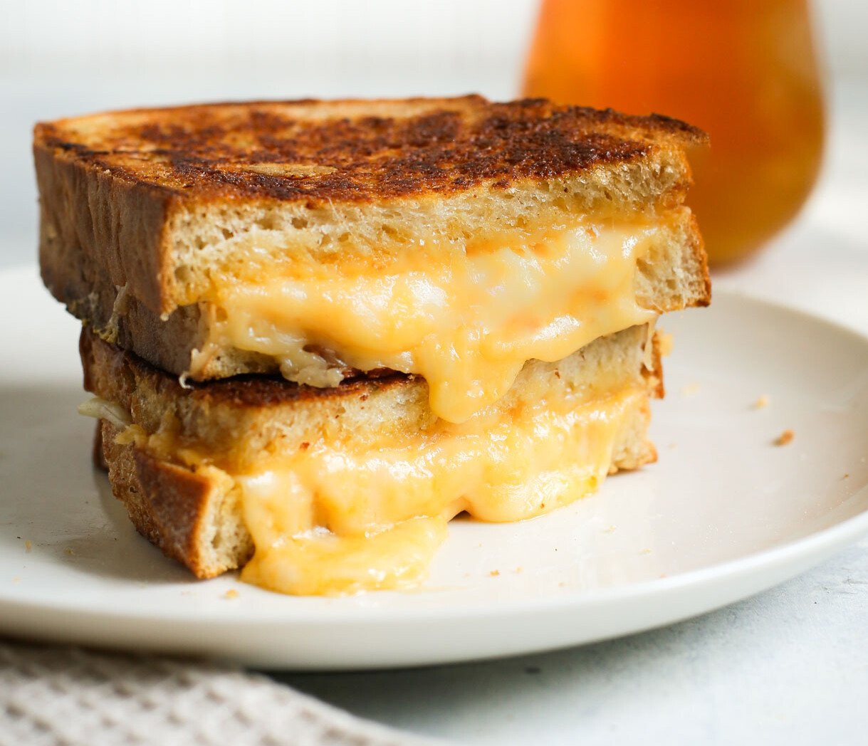 melty sourdough grilled cheese stacked on white plate