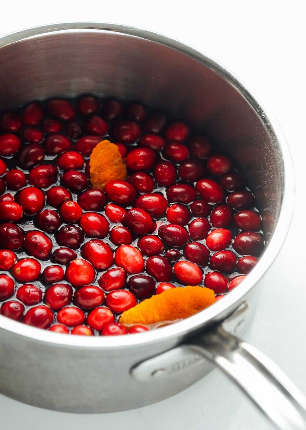 cranberries and orange peel in stainless steel pot