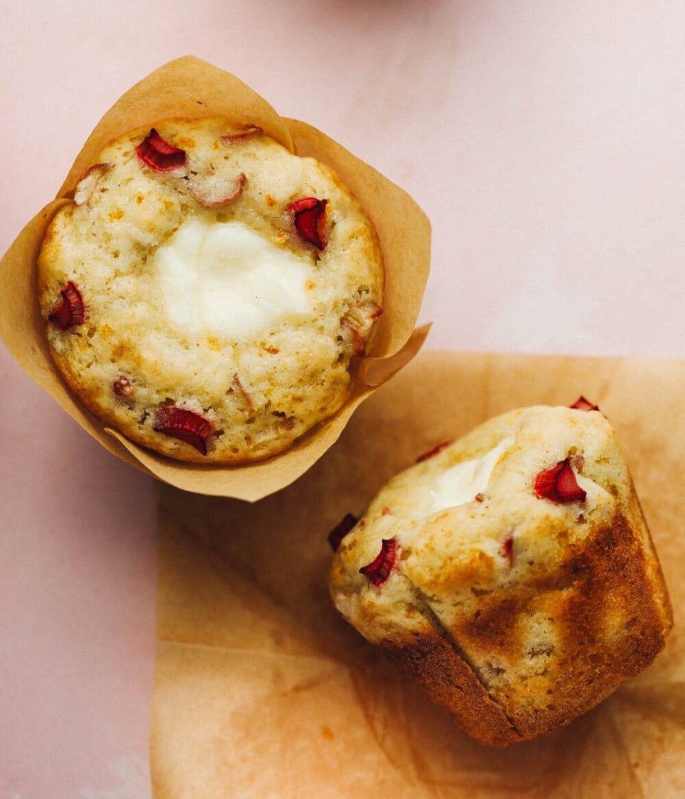 two rhubarb muffins on parchment paper