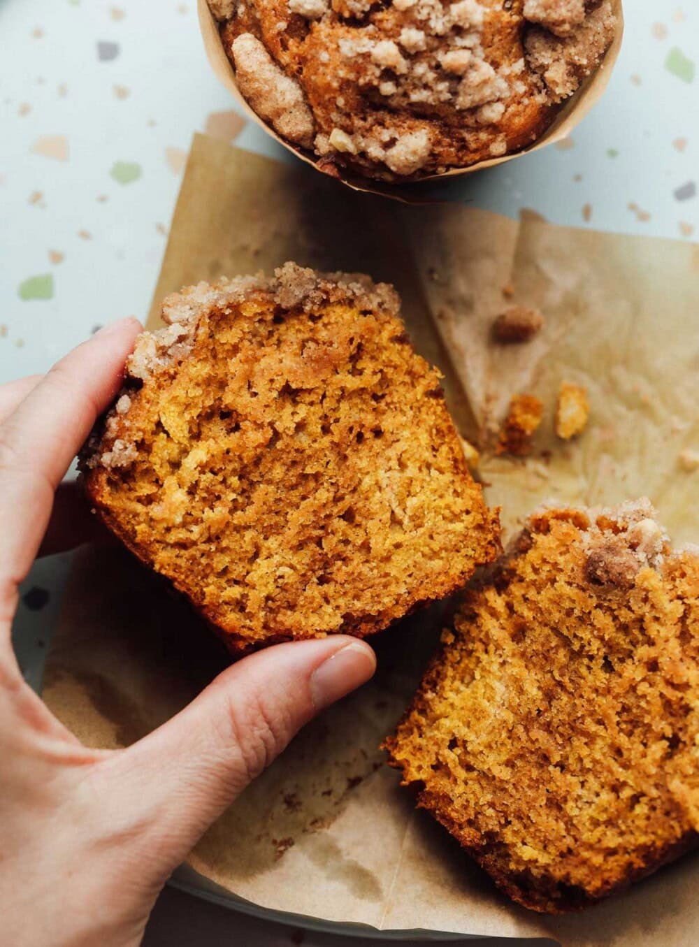 holding pumpkin muffin in hand