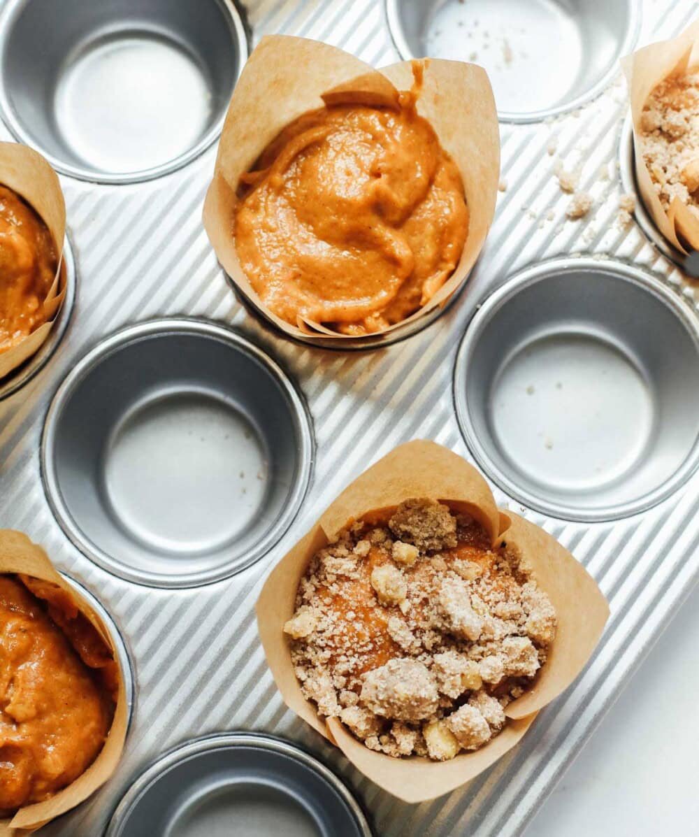 muffin tins filled with pumpkin muffin batter