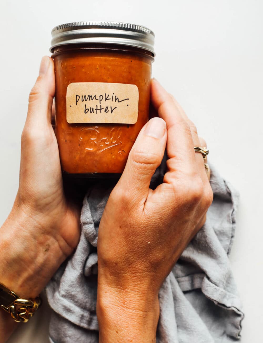 holding a jar of pumpkin butter in hands