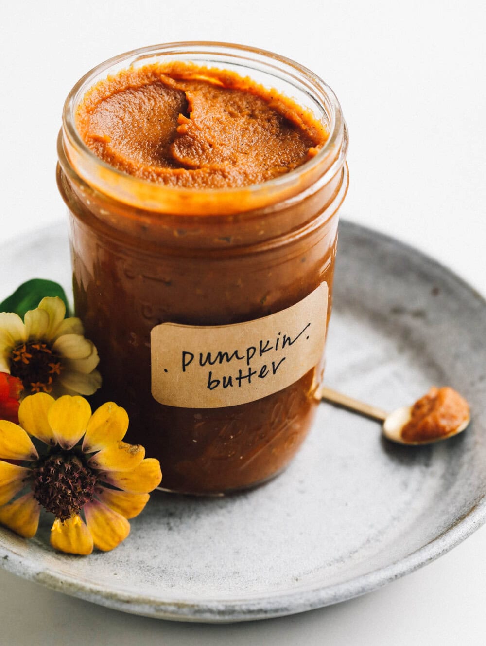 pumpkin butter in a jar on a blue plate, flowers too. 