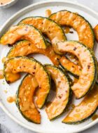 roasted kabocha squash wedges with miso glaze on a white plate