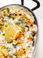 baked dill pickle dip with potato chip for scooping