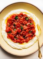whipped mozzarella with tomatoes on top on a yellow plate