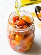 pouring olive oil onto cherry tomatoes
